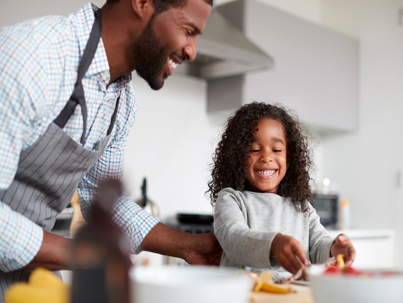Happy father and daughter make food in the kitchen together in home that uses a YORK Heat Pump.