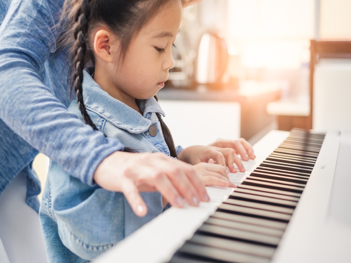 Young girl learns how to play piano in home that uses a YORK Steam Humidifier for improved air quality.
