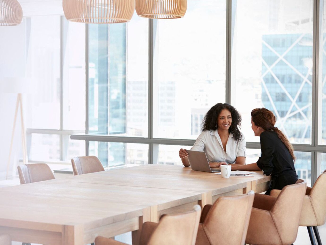 Two female colleagues discussing in a meeting room in office
