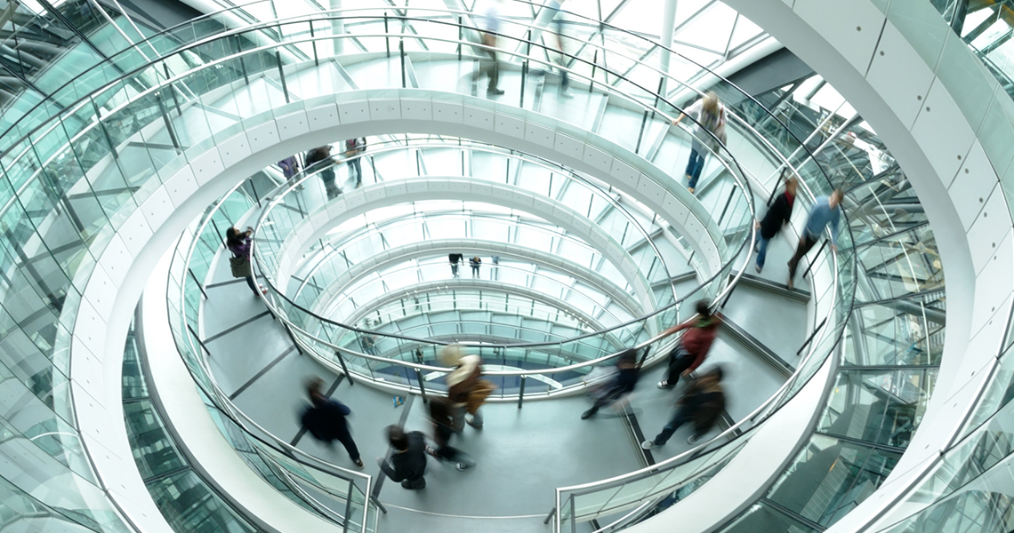 Motion-blur shot of people walking down a circular staircase