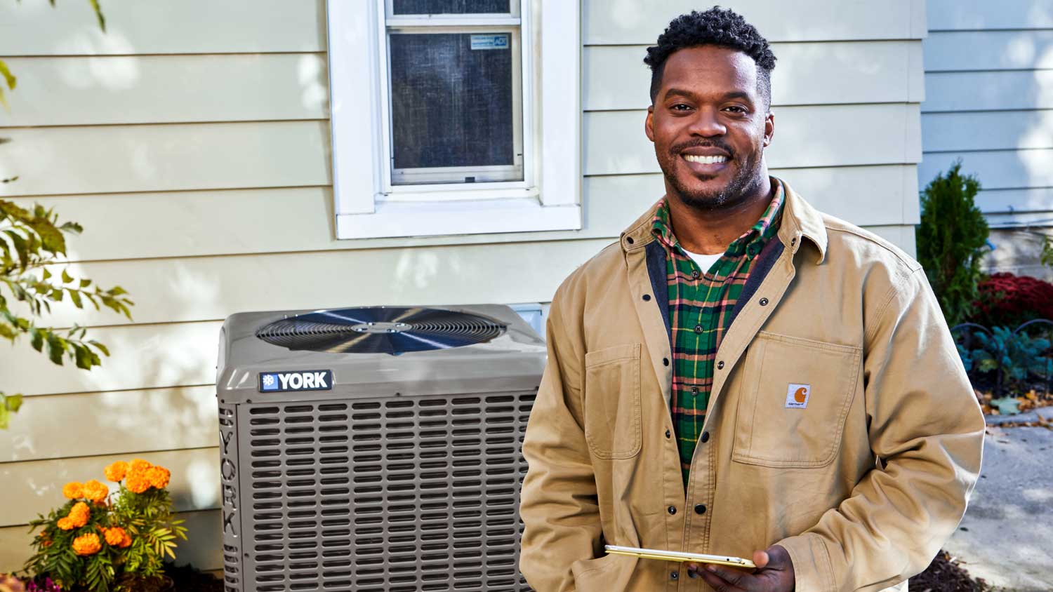 Contractor smiling in front of YORK AC unit