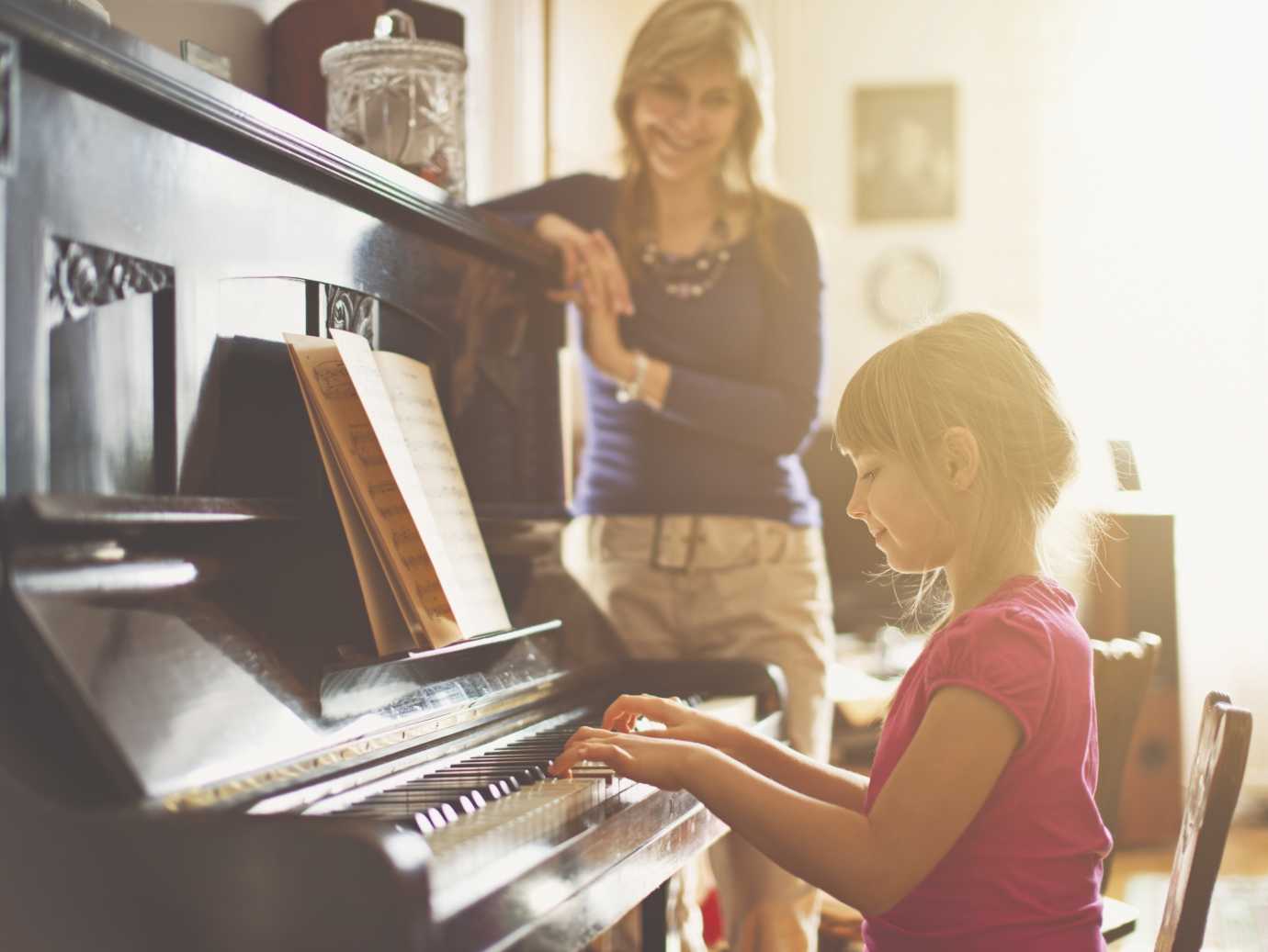 Child plays piano while mother watches in a home that uses a YORK Gas Furnace.