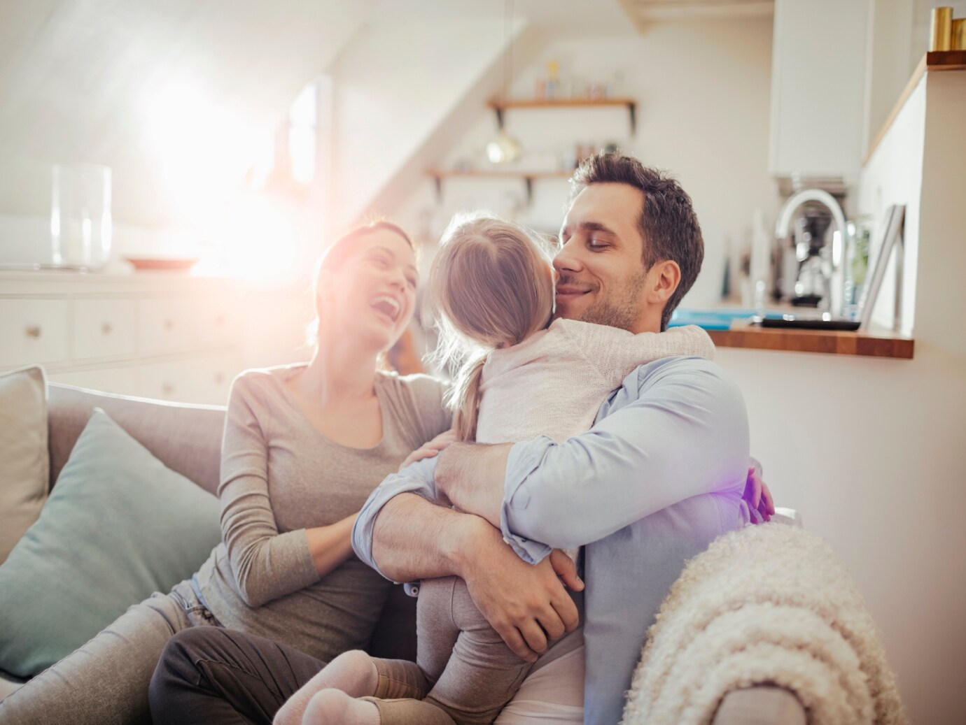 Young happy family plays on couch in home that uses a YORK Gas Furnace for efficiency, convenience and reliability.