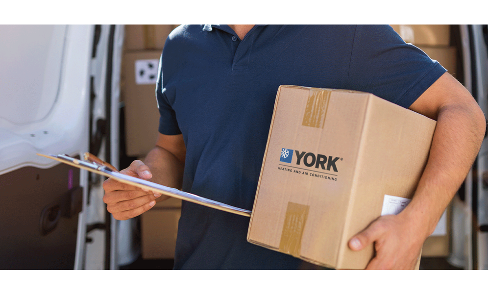 Postman holding a cardboard box with a YORK logo and a clipboard